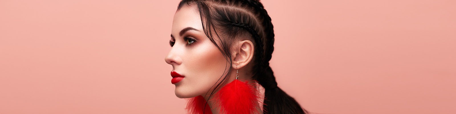 A woman with long hair and red feathers in her ear.