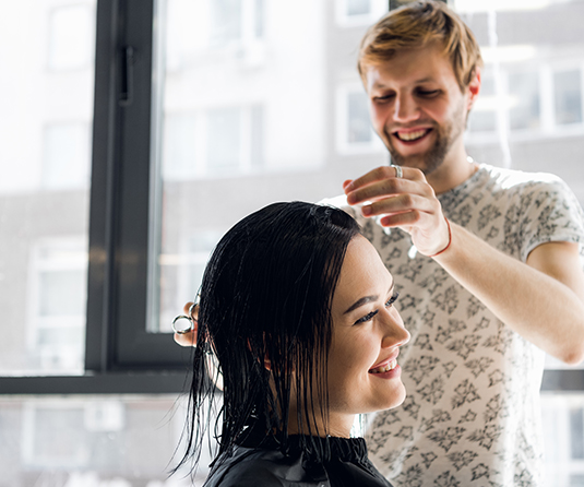 A woman getting her hair done by a stylist.