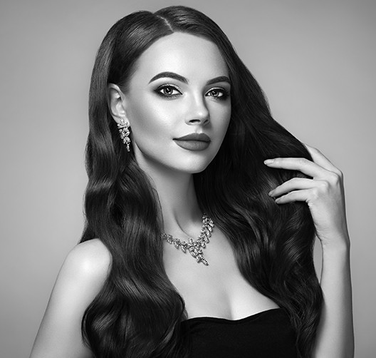 A woman with long hair wearing jewelry and posing for the camera.