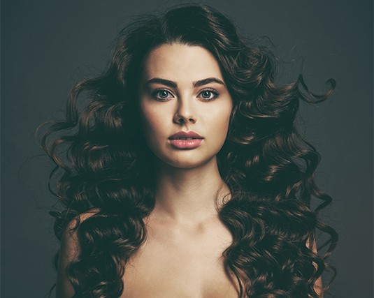 A woman with long hair is posing for the camera.