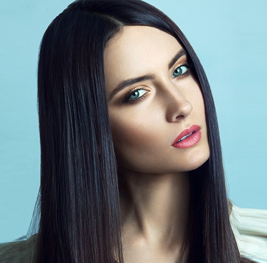 A woman with long black hair and blue eyes.