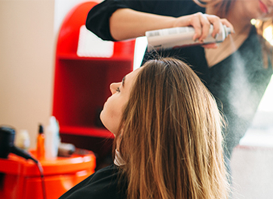 A woman getting her hair dried by another person.