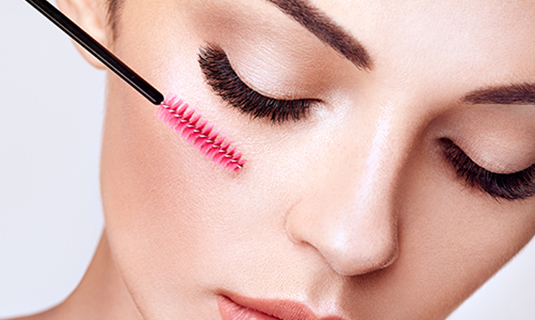 A woman with pink mascara on her lashes.