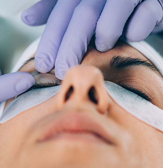 A person getting their eyes cleaned by a doctor.