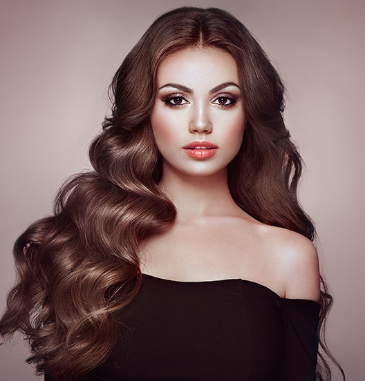 A woman with long hair is posing for the camera.