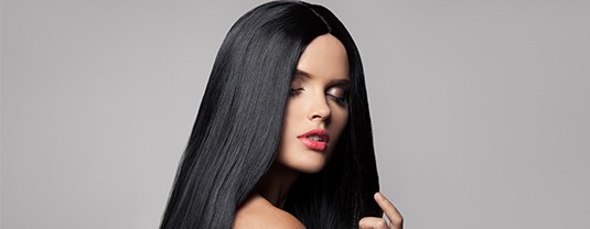 A woman with long black hair is posing for the camera.