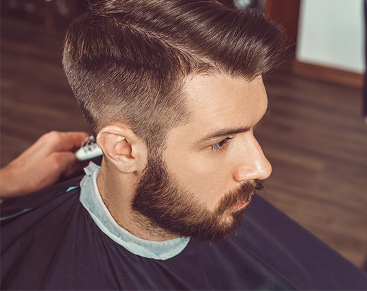 A man getting his hair cut by another person