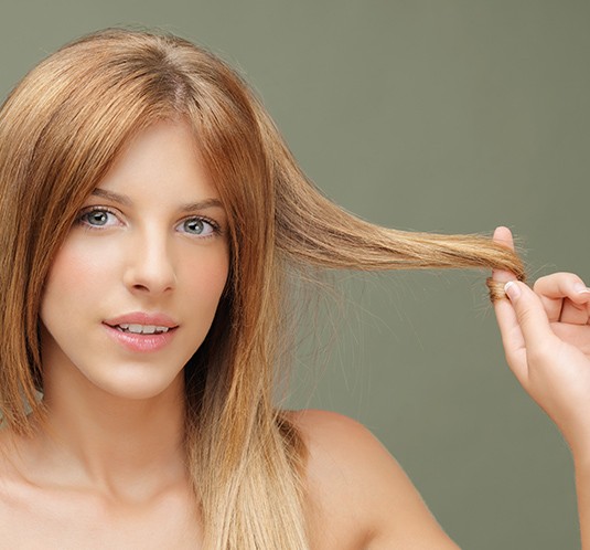 A woman is brushing her hair with a brush.