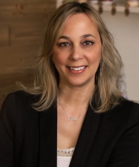 A woman in black jacket smiling for the camera.