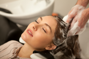 Customer receiving a haircut and hair treatment at a premium hair salon in Westchester.